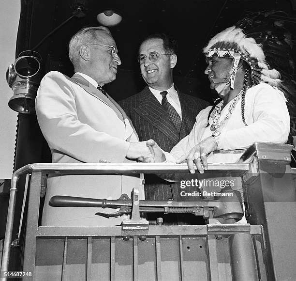 Aboard his homeward-bound train during the 1948 presidential campaign, President Harry Truman receives a blanket and a handshake from Navajo Chief...