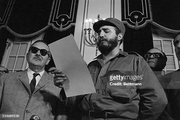 Fidel Castro reads the oath of office and is sworn in as prime minister of Cuba on February 16, 1959. At left is acting president Manuel Urrutia and...