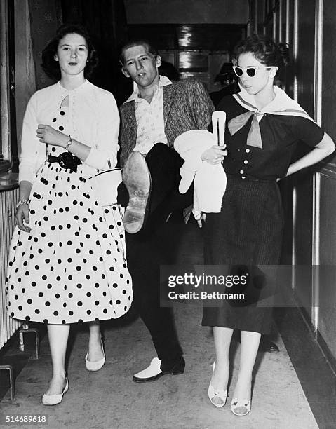 London, England: Rock 'n' Roll singer Jerry Lee Lewis seems to getting a kick out of life as he arrives at the airport here May 27th before getting a...