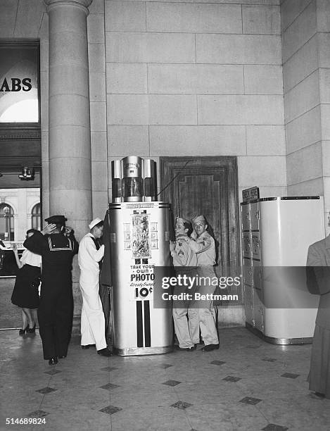 While these servicemen were waiting in line at the photograph machine that enables the customer to take this one picture for a dime, our photograher...