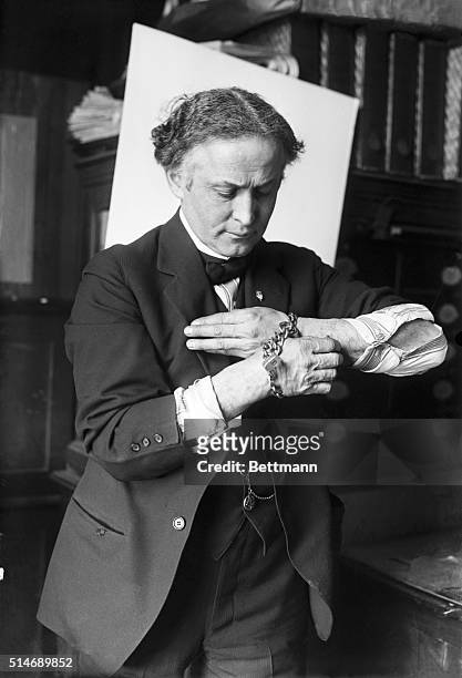 Harry Houdini getting out of handcuffs.