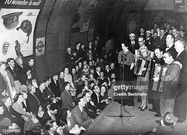 London, England: Driven underground into the subway by Nazi bombs, these Londoners pictured at the Aldwych Station forget, for the time being, the...