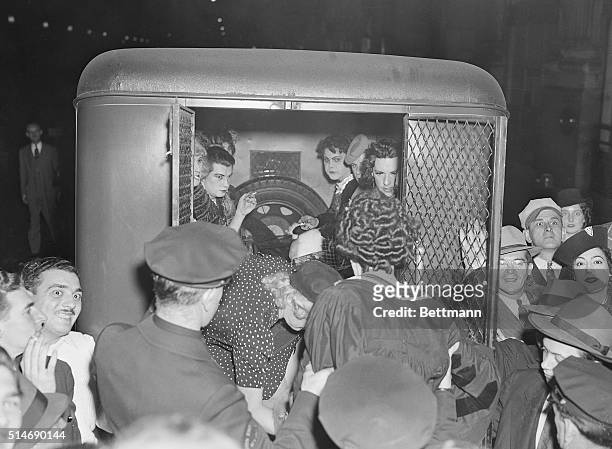 New York: A group of revelers, all garbed as women, are shown being loaded into a "pie-wagon" as police raided a masque ball Manhattan Center, early...