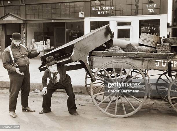 Comedian taking piano off of junk wagon. SEE NOTE