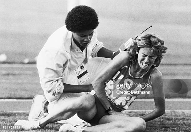 Track official attempts to comfort a crying Mary Decker after Decker's fall in the women's 3000-meter run at the 1984 Summer Olympics. Decker fell...