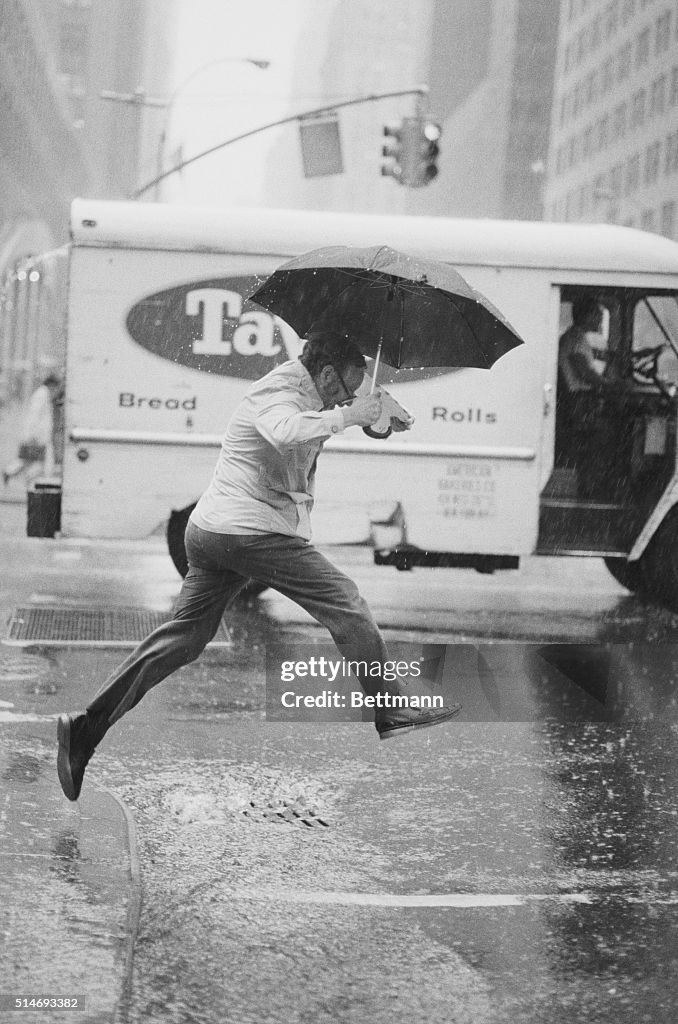 Pedestrian Leaping Over Puddle