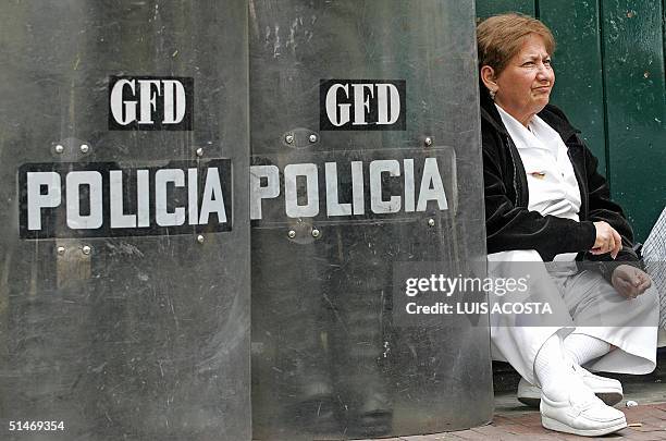 Un enfermera, junto a policias, descansa cuando sus companeros se manifiestan frente a la iglesia de San Francisco en Bogota el 11 de octubre de...