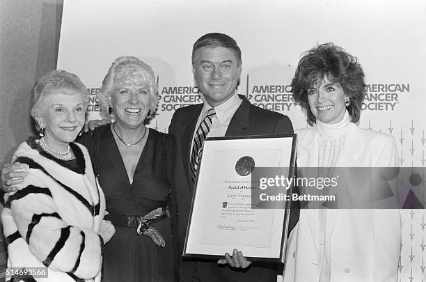 Larry Hagman with an award given to him by the American Cancer Society, for chairing the Great American Smokeout for four years. Beside him are his...