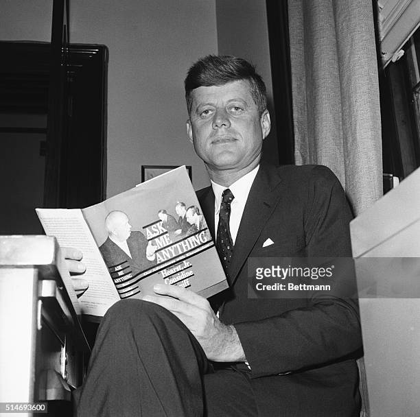 Senator John F. Kennedy reads a book titled Ask Me Anything. Kennedy was soon to be chosen for the Democratic presidential ticket.