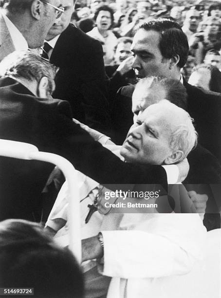 Aides hold Pope John Paul II after being shot by a terrorist. The Pope later recovered from his wounds.
