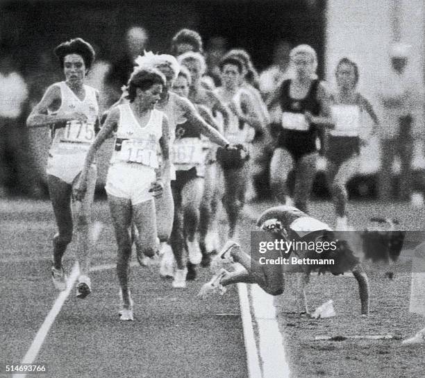 South African runner Zola Budd watches her chief competitor, American Mary Decker, fall to the ground in the final of the women's 3000-meter run at...