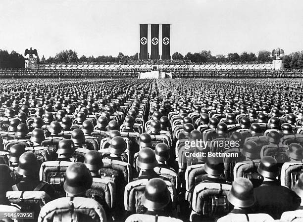 Huge crowd of soldiers in combat gear stands at attention beneath the reviewing stand at Nuremberg, Germany, listening to a speech by the German...