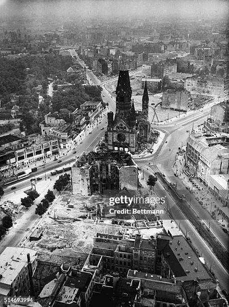 The Kaiser Wilhelm Memorial Church, suffering from extensive bomb damage, sits amidst rubble in Berlin, Germany.