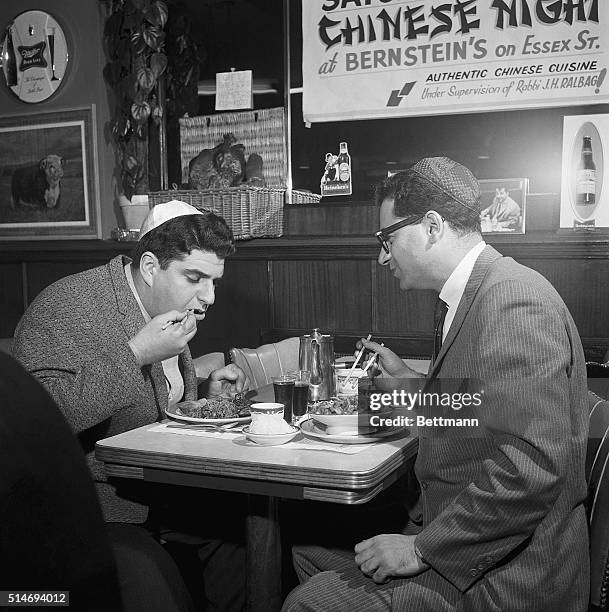 Two men enjoy Chinese cuisine prepared by Chinese chefs within the guidelines of kosher food preparation at a restaurant.