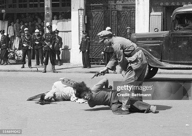 EXECUTION IN SHANGHAI. A SHANGHAI MUNICIPAL POLICEMAN KILLS A COMMUNIST AGENT MOMENTS AFTER HAVING PUT ANOTHER PRISONER TO DEATH DURING STREET...