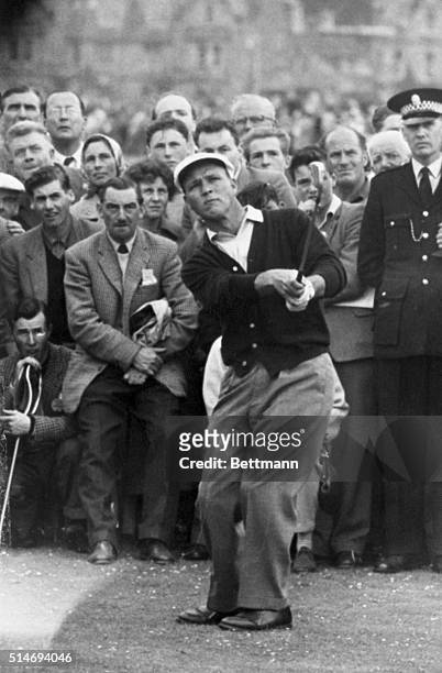 The gallery intently watches a shot made by American golfer Arnold Palmer as he competes in a qualifying round of the 1960 British Open in St....