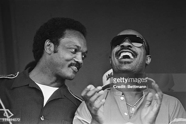 Presidential candidate Jesse Jackson leans towards singer Stevie Wonder as he leads a crowd in a rendition of the campaign chant "Run, Jesse, Run."