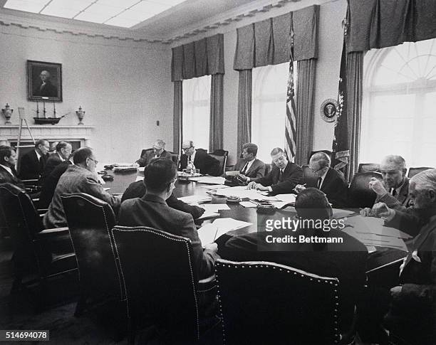 President Kennedy meets with his cabinet officers and advisers in October 1962 about the Cuban missile crisis. Seated at the table are Robert...