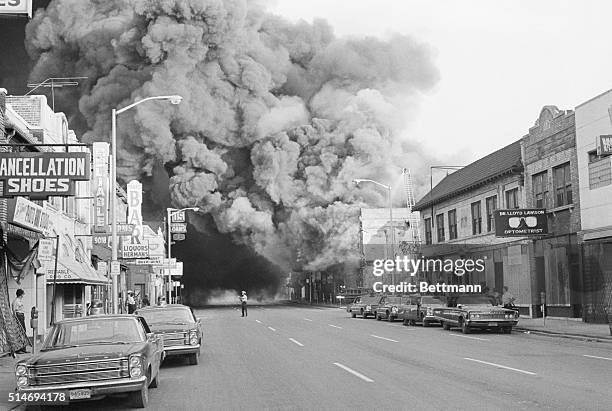 Residents watch as fire consumes a building on Detroit's West Side during racial riots.