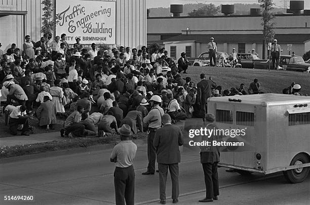 Police officers stand near a paddy wagon as African American protesters gather in front of the Traffic Engineering Building in Birmingham, Alabama. |...