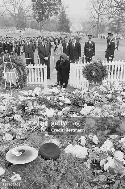 Jackie Kennedy wipes tears away as she kneels at the grave of her late husband, on November 28, 1963. Behind her at the Arlington National Cemetery...