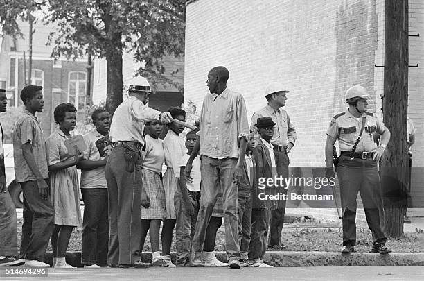 African American children participating in a Civil Rights protests wait for a police van to take them to jail in Birmingham, Alabama.