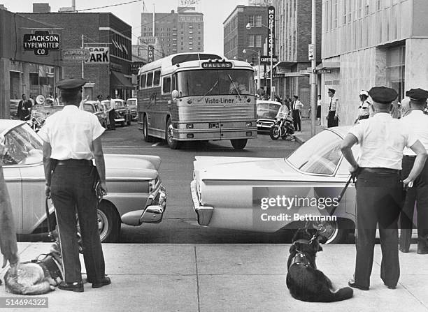 As a Trailways bus carrying Freedom Riders arrives in Jackson, Mississippi, police officers with dogs prepare to arrest and jail those on board, 24th...