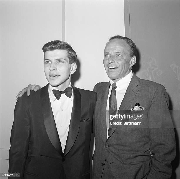 Portrait of Frank Sinatra and his son, Frank Sinatra, Jr., arm in arm, as they greet each other at the Americana Hotel where Frank Jr. Is performing...