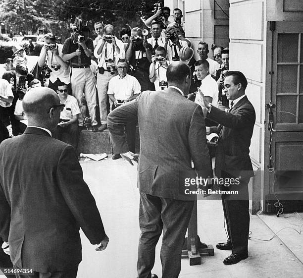 Governor of Alabama George Wallace hold up his hand to Deputy US Attorney Nicholas Katzenbach as he bars entrance to two African American students to...