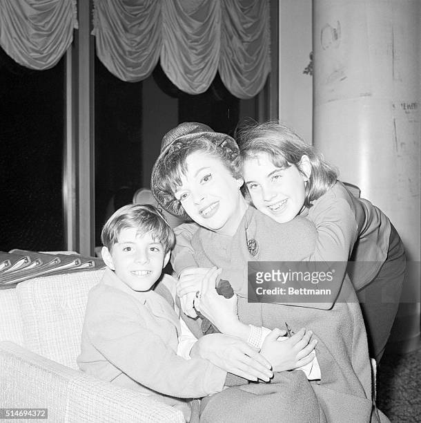 Los Angeles, CA: Judy Garland hugs her two children, Joey and Lorna after her arrival at International Airport here 1/11. She returned home after...