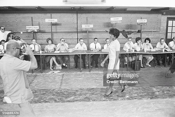 College student Vivian Malone enters the University of Alabama's Foster Auditorium to register for classes, walking past workers manning desk on one...