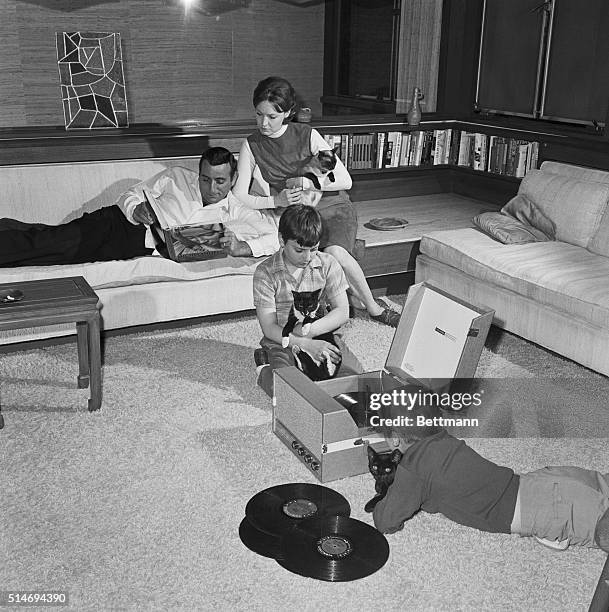 Tony Bennett and his wife Sandy look at a volume of Michelangelo reproductions as their sons, Danny and Dae-Dae listen to records on the floor at...