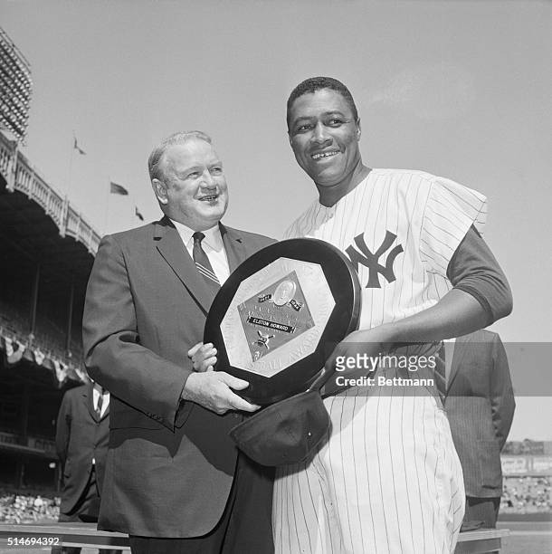 New York Yankee catcher Elston Howard receives the American League's 1963 Most Valuable Player Award from league president Joe Cronin before the...