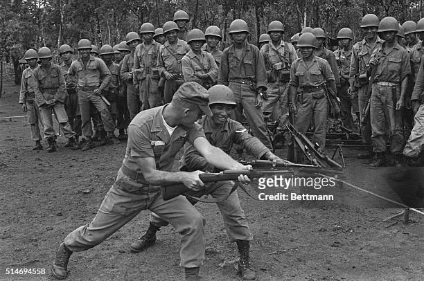 Vietnamese trainees watch as US Ranger Lt. Bruce G. Smally instructs Corporal Y. Bhung on how to use a bayonet. The US Special Forces are training...