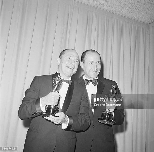 Johnny Mercer and Henry Mancini stand happily with their Oscar awards for "Days of Wine and Roses" in the 1963 "Best Song" category.