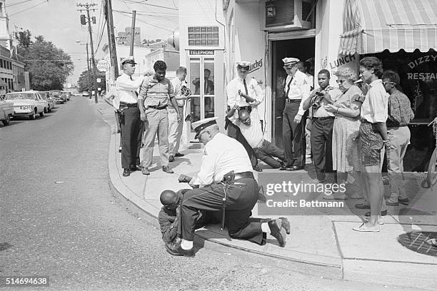 Mrs. Gloria Richardson, Chairman of the Cambridge Non-Violent Action Committee watches as sit-in demonstrators Johnny Weeks James Lewis and Dwight...