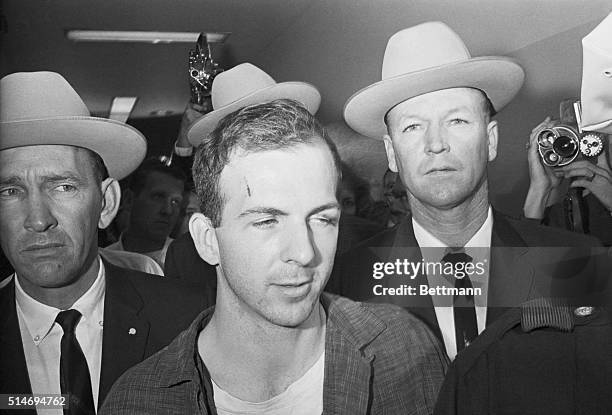 Texas Rangers escort accused Kennedy assassin Lee Harvey Oswald into a Dallas police facility.