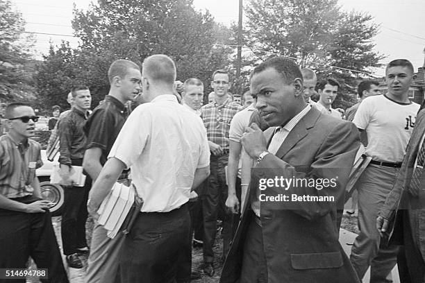 African American student James Meredith walks across the University of Mississippi campus after class amid the stares and jeers of fellow students....