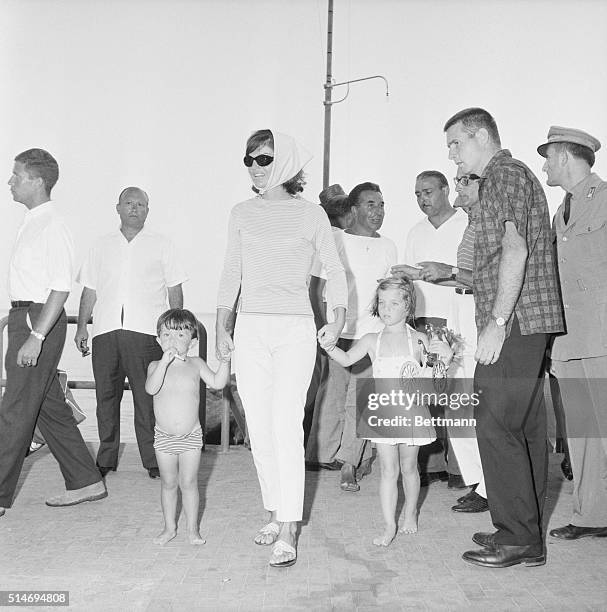 First Lady Jackie Kennedy holds the hands of daughter Caroline and nephew Anthony Radziwill, as they go to the beach in Amalfi. The Kennedys are...