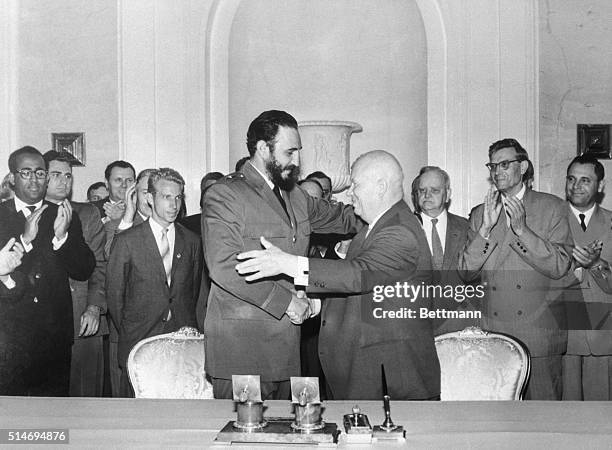 Premiers Nikita Khrushchev of the Soviet Union and Fidel Castro of Cuba shake hands and start to embrace in Moscow. Castro made a state visit to the...