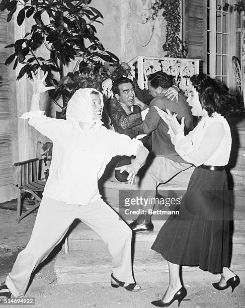 London, England:Actress Katharine Hepburn grits her teeth and bares her claws in the direction of screen queen Elizabeth Taylor as actor Montgomery...