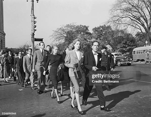 Prominent motion picture stars, lead by Lauren Bacall and Humphrey Bogart, cross a Washington, DC street to protest hearings by the House Committee...