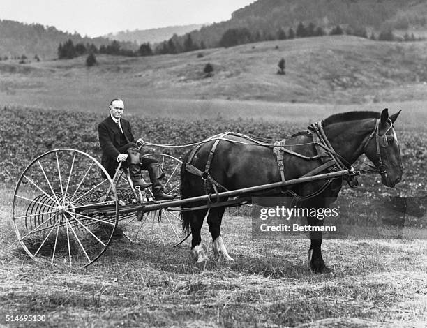 Former U.S. President Calvin Coolidge drives a hay rake on his Vermont farm in 1931, two years after leaving the presidency.