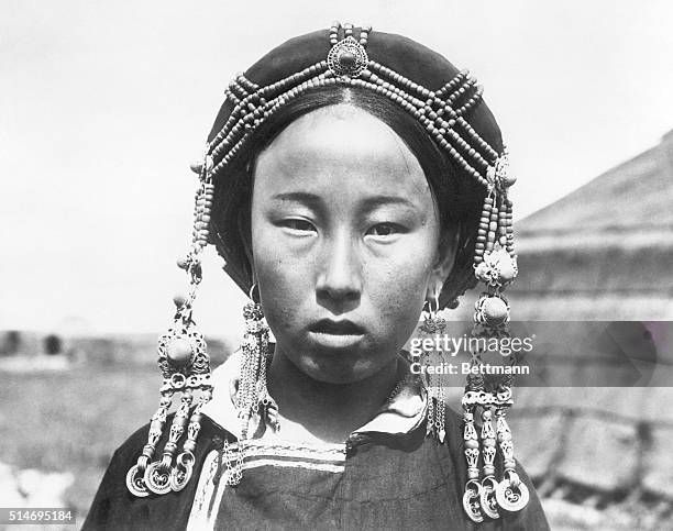 Gobi Desert:Roy Chapman Andrews Expedition. 17-year-old inner Mongolian maid, wearing the customary head dress which consists of amber beads and...