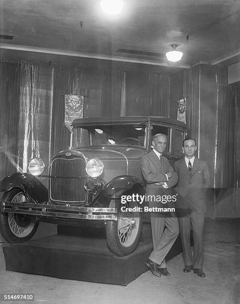 Henry Ford Full length pose with son, Edsel, standing in front of a new model Ford.