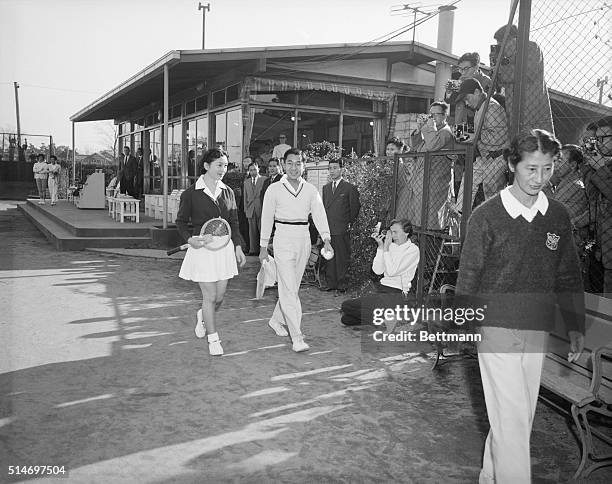 Tokyo, Japan: Crown Prince Akihito and his bride-to-be Michiko Shoda, proceed to a tennis court at the Tokyo Lawn Tennis Club to play a few sets of...