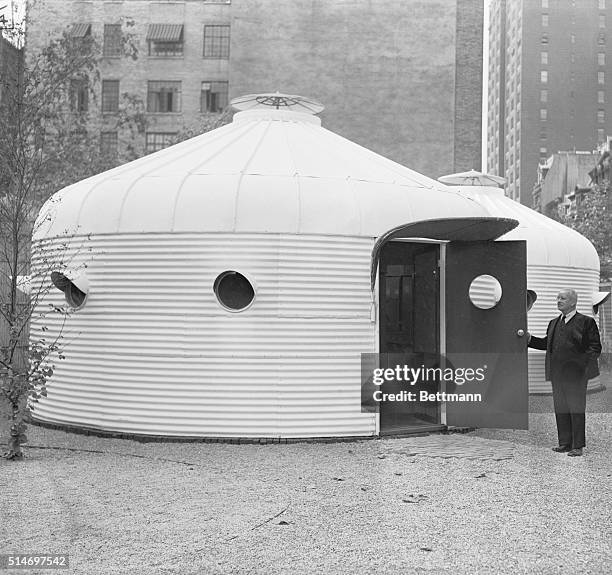 New York: R. Buckminster Fuller, engineer, inspects the entrance to the bomb shelter which he invented. Known as the Dymaxion Unit, it is on exhibit...