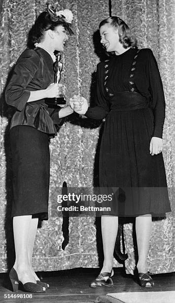 Swedish actress Ingrid Bergman receives Oscar from Jennifer Jones.