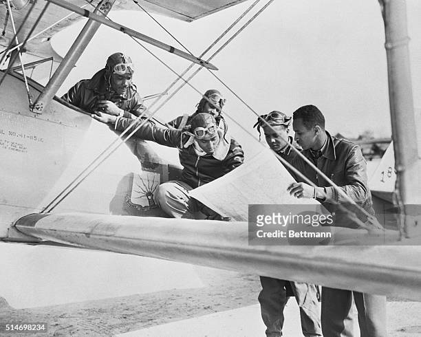 Cadets at the Negro Training Center examine a map before taking off in a biplane for a training exercise. The pilots would later be known as the...