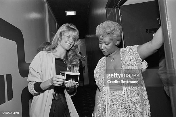 Super model Christie Brinkley asks Aretha Franklin for an autograph on a Polaroid picture backstage at during the "Merv Griffin Show."